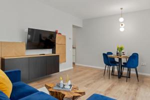 a living room with a blue couch and a table at Mido Park Apartment with Private Parking & Self Check-in in Bucharest