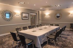 a conference room with a long table and chairs at Rosslea Hall Hotel in Rhu