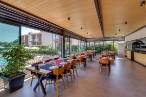 un restaurante con mesas, sillas y ventanas grandes en Celeste Bella Luxury Hotel & Spa, en Ortakent