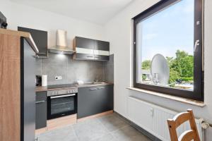 uma cozinha com um lavatório e uma grande janela em Rheinische Gemütlichkeit, Sali Homes Zentrales Heim in Kleve em Kleve
