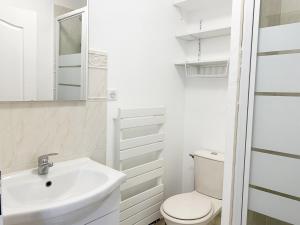 ein weißes Bad mit einem Waschbecken und einem WC in der Unterkunft Le Matisse in Mainvilliers