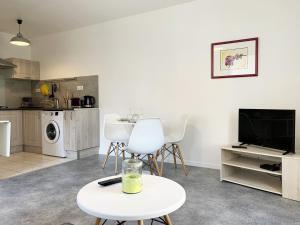 ein Wohnzimmer mit einem Tisch und einem TV in der Unterkunft Le Matisse in Mainvilliers
