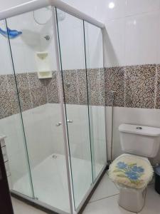 a bathroom with a shower and a toilet at Praia de Jaúa, Piscina privativa, churrasqueira. in Camaçari