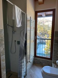 a bathroom with a shower and a toilet and a window at Hotel Chalet Casa Cesana in Cesana Torinese