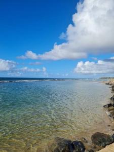 a large body of water with rocks on the shore at Praia de Jaúa, Piscina privativa, churrasqueira. in Camaçari +25 photos