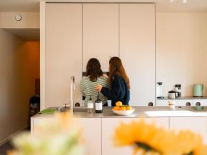 duas mulheres numa cozinha a falar em Living Lodges - Durbuy em Durbuy