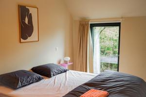 Duas almofadas numa cama num quarto com uma janela em Living Lodges - Durbuy em Durbuy
