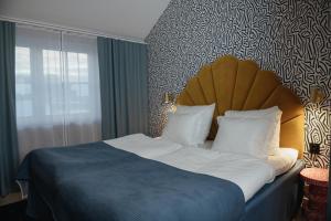 a bedroom with a large bed with a blue comforter at Clarion Hotel Örebro in Örebro