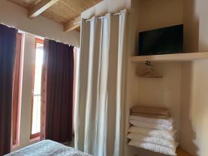 a bedroom with a bed and a television and towels at Hotel Chalet Casa Cesana in Cesana Torinese