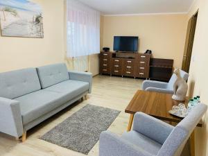 a living room with a couch and chairs and a table at Hotel Skaut in Chorzów