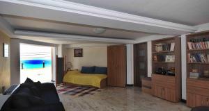 ein Wohnzimmer mit einem Bett und einem Bücherregal in der Unterkunft LIVAS Corinth Seaside Family Apartment in Kórinthos