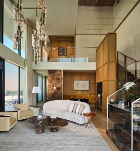 un soggiorno con divano bianco e scala di The Lana - Dorchester Collection a Dubai