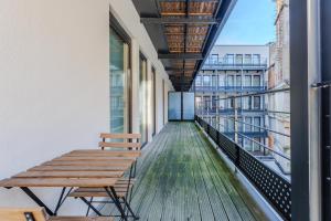 Sweet Inn - Stassart في بروكسل: شرفة على مقاعد خشبية في مبنى