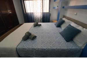 1 dormitorio con 1 cama grande con almohadas azules en Apartamento Carmix, en Portimão