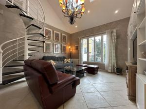 ein Wohnzimmer mit einer Wendeltreppe und einer Couch in der Unterkunft La Maison des Lumières in Chartres
