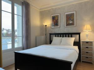 ein Schlafzimmer mit einem großen Bett und einem Fenster in der Unterkunft La Maison des Lumières in Chartres