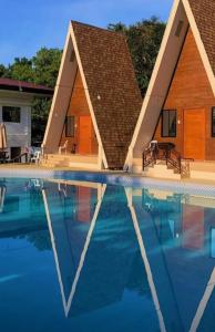 uma casa é refletida na água de uma piscina em Beup Inland Resort 