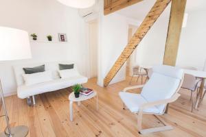 uma sala de estar com mobiliário branco e uma mesa em Historical Apartment Santos III em Lisboa