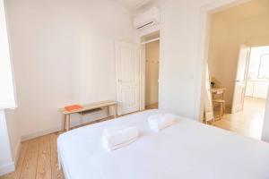 Dormitorio blanco con cama blanca y mesa en Historical Apartment Santos III en Lisboa