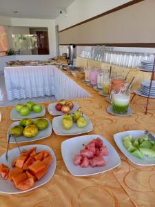 a long table with plates of fruit on it at Hotel Viña del Sur in Tarija