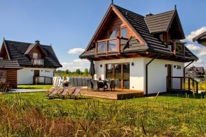 une maison dotée d'une terrasse avec une table et des chaises dans l'établissement Korona Gór, à Białka Tatrzańska