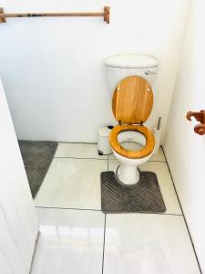 a bathroom with a toilet with a wooden seat at Low budget Cottage- Gqeberha (no loadshedding) in Mount Road