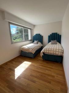 2 camas en una habitación con ventana en Maison de luxe en Saint-Gratien