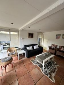 uma sala de estar com um sofá e uma mesa em Holiday Home 'Beautifull Water' em Lanaken