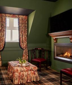 a living room with a table and a fireplace at Slieve Donard in Newcastle