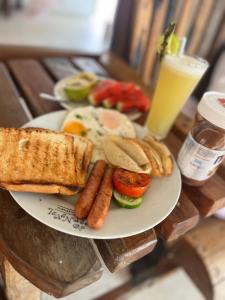 un piatto di prodotti per la colazione con salsiccia e pane tostato di The cliff room a Pongwe