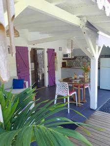 ein Wohnzimmer mit lila Türen und einem Tisch in der Unterkunft Ti kaz a Max in Saint-François