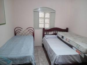 Duas camas num quarto com uma janela em casa c/4 dormitórios e piscina em Botucatu