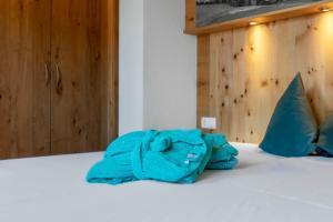 a blue robe laying on a bed at Ferienhaus 12 im Feriendorf Kirchdorf in Kirchdorf in Tirol