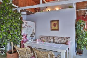 a white table and chairs in a room with a plant at Hotel Sonne - Adults Only in Kaş