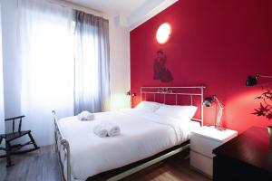 Un dormitorio rojo con una cama con toallas. en PrimoPiano - Palmaria, en Milán