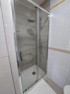 a shower with a glass door in a bathroom at Sirena Center apartment in Seville +7 photos