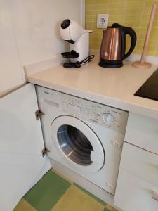 a washing machine under a counter in a kitchen at Sirena Center apartment in Seville