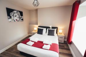 a bedroom with a bed with a red and white blanket at The Stay Company, Devonshire Court in Nottingham