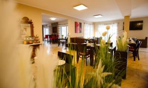 a dining room with tables and chairs in a restaurant at Auwald Hotel in Ingolstadt