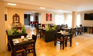 a dining room with tables and chairs in a restaurant at Auwald Hotel in Ingolstadt