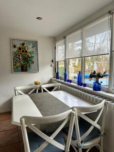 a dining room with a table and chairs and windows at Holiday Home 'Beautifull Water' in Lanaken