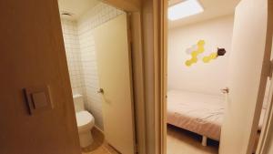 a small bathroom with a toilet and a bed at G Yongsan Inn in Seoul +74 photos