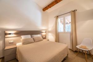 a white bedroom with a bed and a window at Résidence Santa Monica in Bonifacio