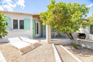 a patio with two chairs and a tree in front of a house at Résidence Santa Monica in Bonifacio