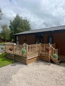 a wooden fence with potted plants in front of a house at Bolton Beer Escape Lodge in Warton