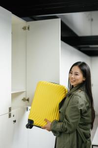 una mujer sosteniendo una almohada amarilla en una habitación en Capsule Hotel Constellation 91, en Leópolis