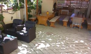 a patio with chairs and a table and a dining room at Apartments Ana-Maria in Fažana