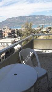 einen weißen Tisch und einen weißen Stuhl auf dem Balkon in der Unterkunft Ionias Penthouse in Korinthos
