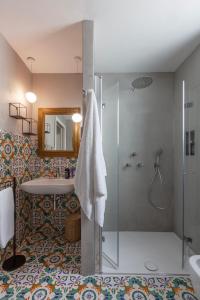 a bathroom with a shower and a sink and a mirror at Frangimare - La Malandrina in Malfa