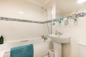 ein weißes Badezimmer mit einem Waschbecken, einer Badewanne und einem Waschbecken in der Unterkunft Modern 3 bedroom home *EVcharging* Garden, Parking in Darlington + 22 Fotos